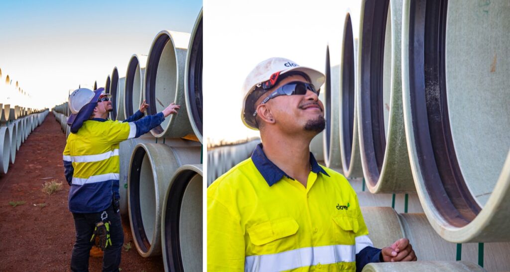 An engineer inspecting rows of stacked pipes.