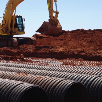 pressure corrugated PE pipe with an excavator in the background